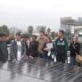 Volunteers gathering around a solar power panel.