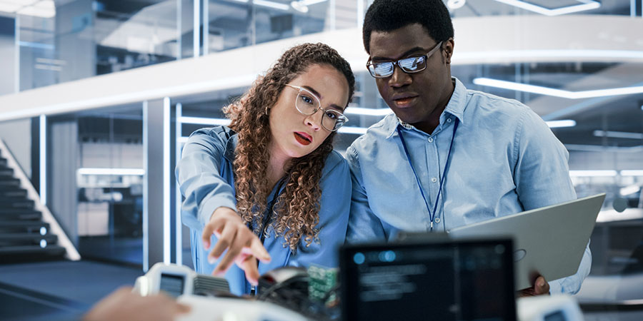 Data analytics professionals discussing an engineering project in an office building.