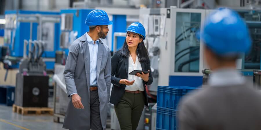 An engineering manager talking to a staff member in a production facility.