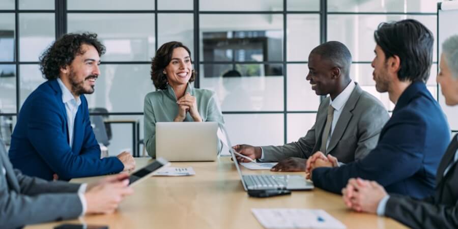 A group of MPA or MBA professionals meet around a conference table.