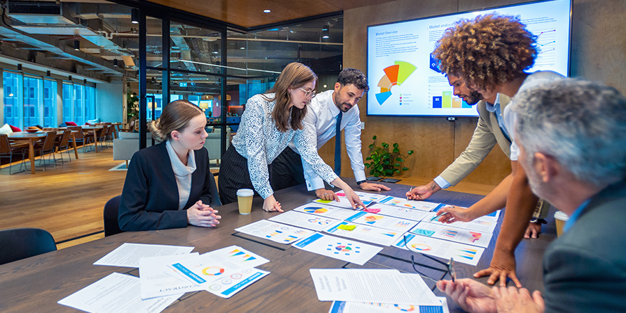 A team of market research analysts reviews data in a conference room.