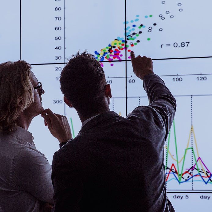 Two men looking at a data set chart