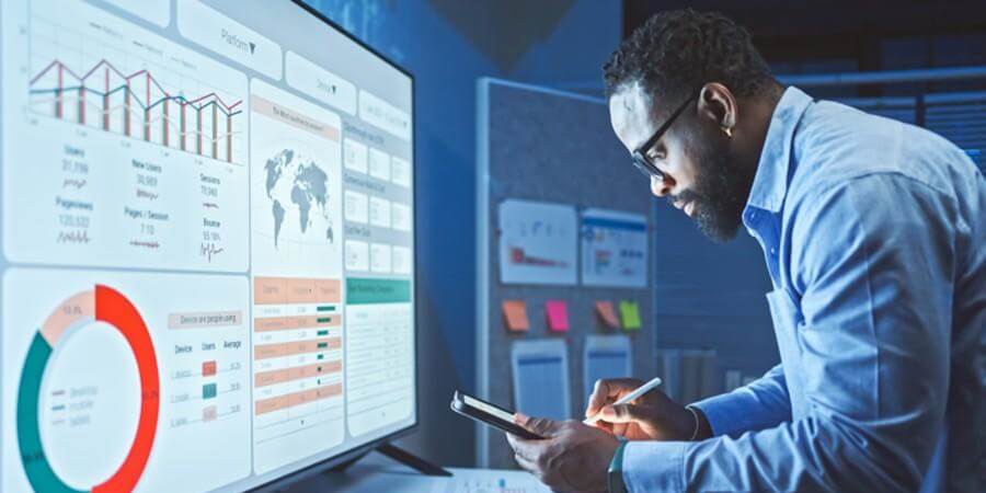A data scientist works on a data visualization dashboard using a smartphone.