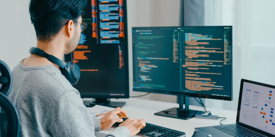 A machine learning engineer reviews code on a monitor.