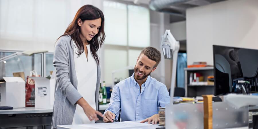 Industrial designers in an office discuss a design project.