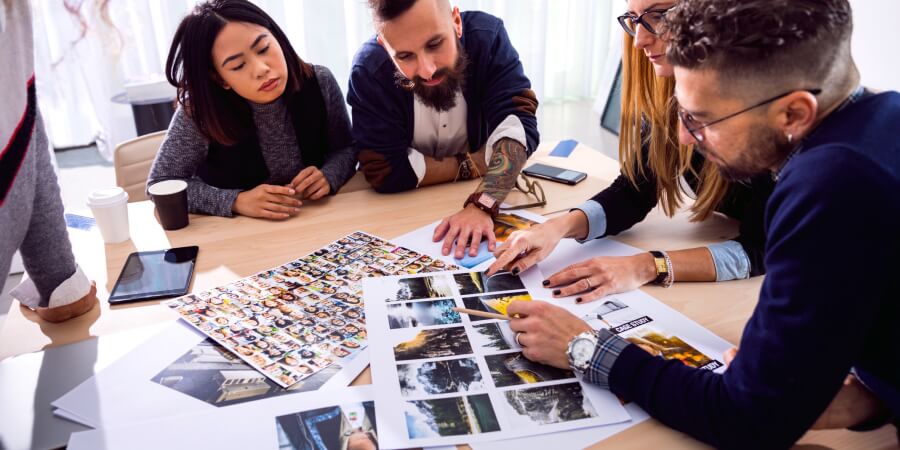 A creative director leads an art team review of images for an advertising campaign.
