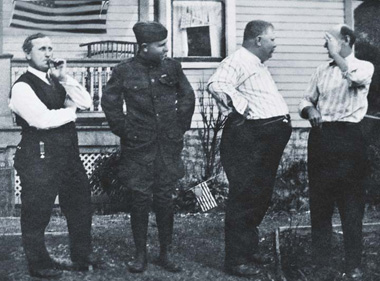 Timed photo of four men standing and talking