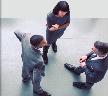 2 guys and a girl in business attire standing facing each other discussing