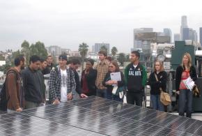 Volunteers gathering around a solar power panel.